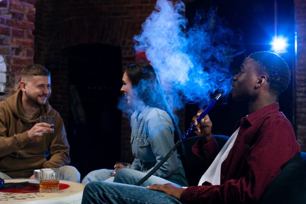 A lively gathering of young people enjoying hookah and alcoholic drinks at hookah shop Tulsa.