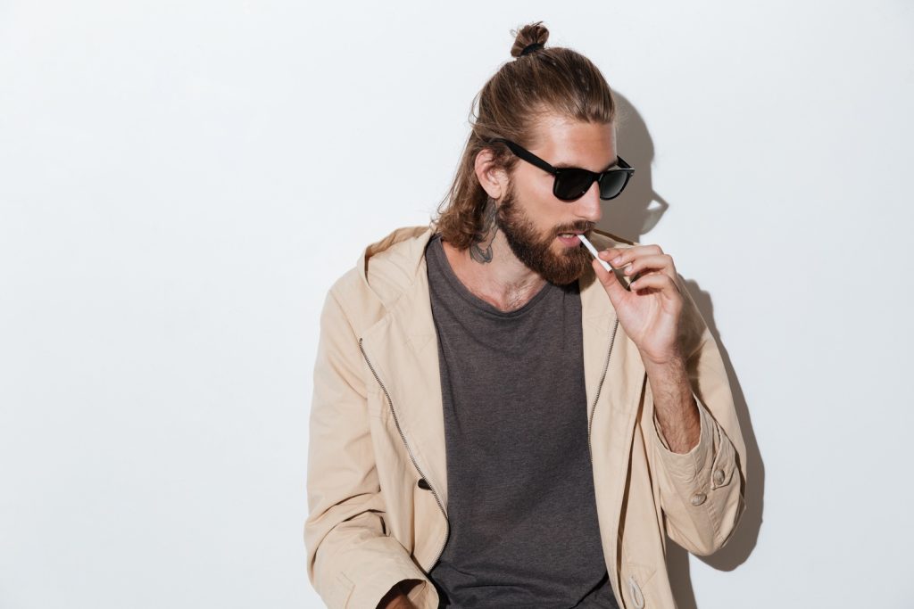Man smoking tobacco wearing sunglasses and brown and black clothing, man smoking at tobacco shop in Stevenson.