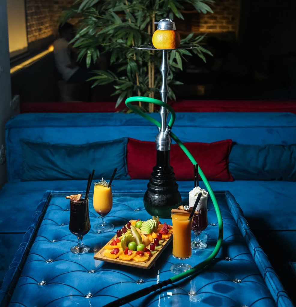 Premium hookah shop Stevenson setting with hookah on blue table, fruits, and drinks