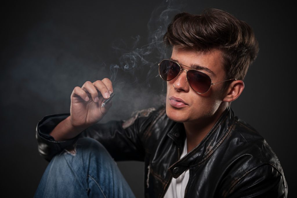 A man wearing sunglasses enjoing his smoke at a Tobacco Store in Tulsa