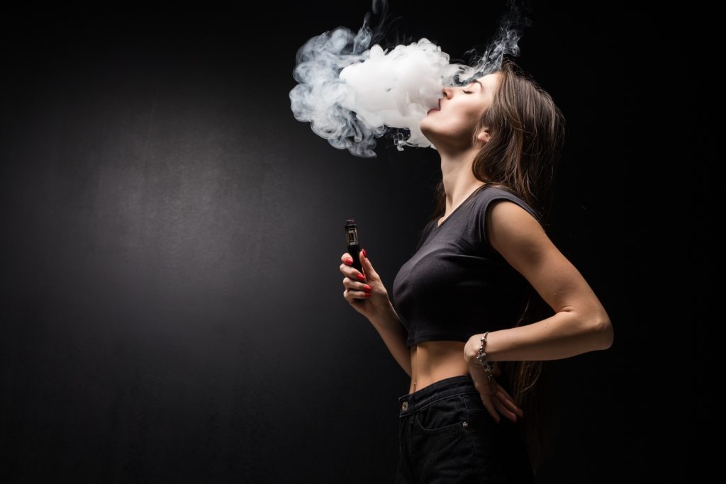 A woman in a black clothing and black background in a vape store in Milwood Estate
