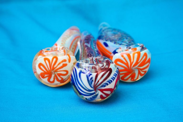 Colorful glass pipes with vibrant orange and blue designs displayed at a trendy smoke shop Tulsa, offering unique smoking accessories.