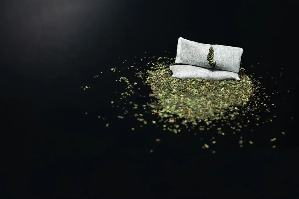 Close-up of tobacco pouches with scattered leaves, highlighting quality products at a tobacco shop in Tulsa.