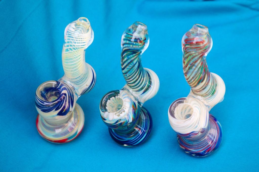 Artistic glass bongs with swirling multicolored patterns available at a creative smoke shop Tulsa, perfect for smoking enthusiasts.
