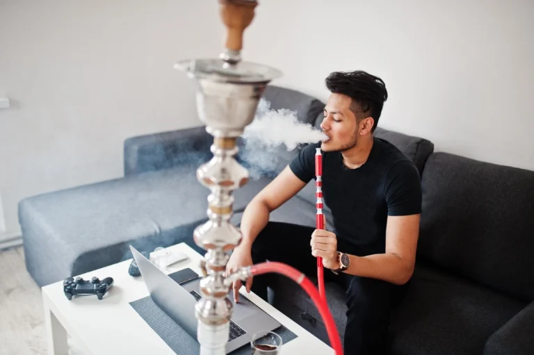 Tobacco Shop Tulsa—hookah session in modern living room with coffee table, laptop, game controller, and smoke