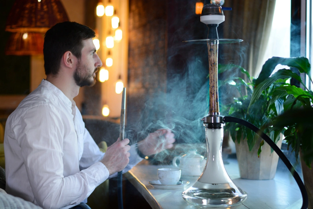 Tobacco Shop Tulsa—indoor hookah session with tea, large hookah, and cozy lounge ambiance near window