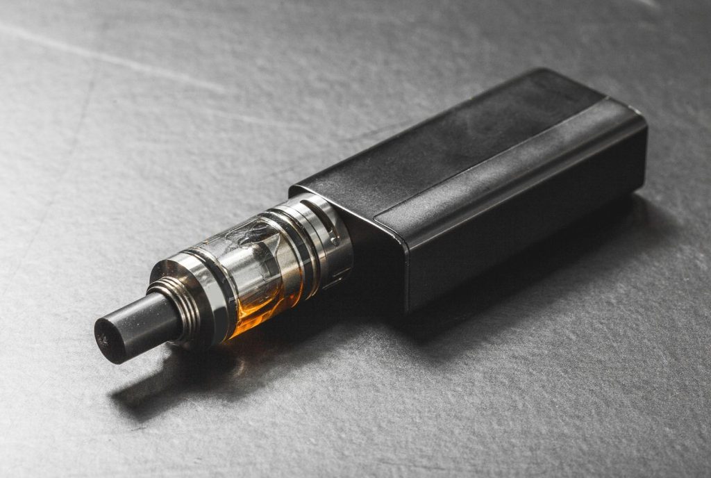 Close-up of a black vape mod with a clear tank. Find advanced hardware at your local vape shop tulsa.