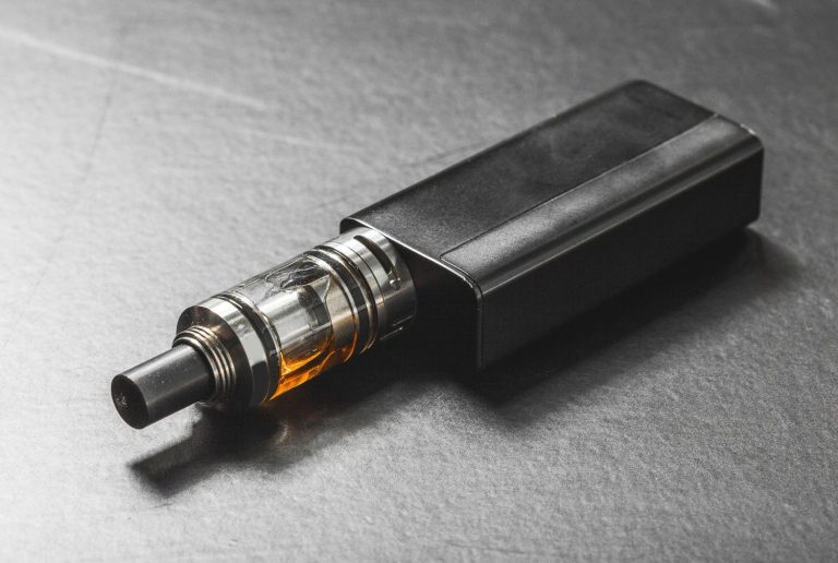 Close-up of a black vape mod with a clear tank. Find advanced hardware at your local vape shop tulsa.