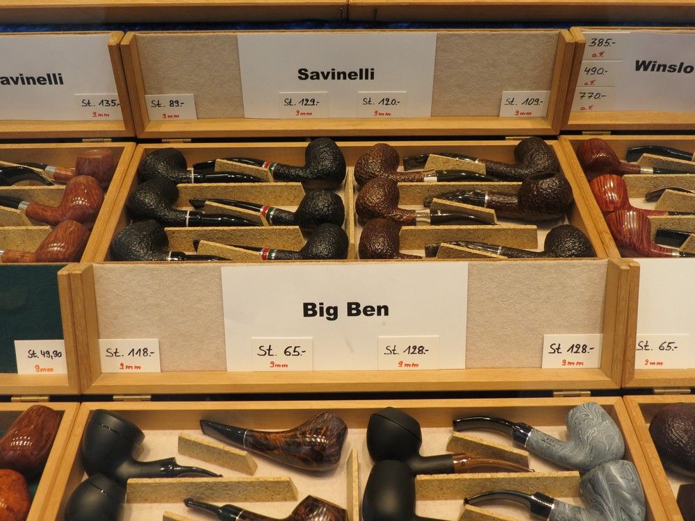 Branded tobacco pipes with price tags neatly arranged in display case at Smoke Shop Tulsa for collectors and smokers.