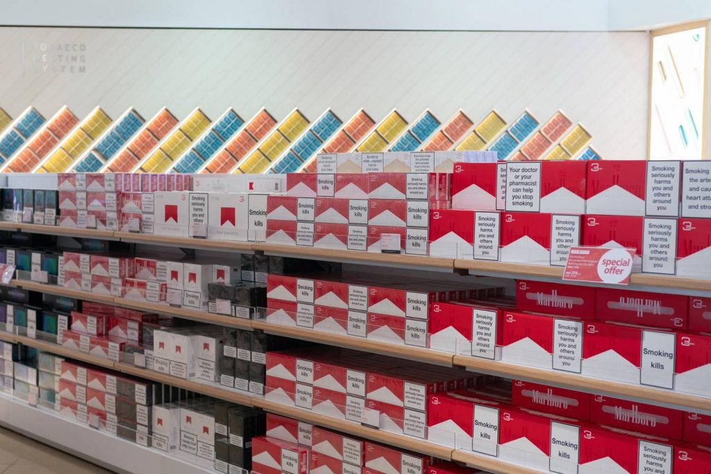 Cigarette packs with health warnings arranged on retail shelves, featured in Smoke Shop Tulsa tobacco product showcase.