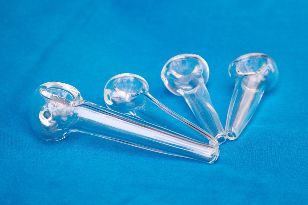 Clear glass pipes with classic bowl design displayed on blue fabric, highlighting minimalist styles from Glass Pipes Tulsa.