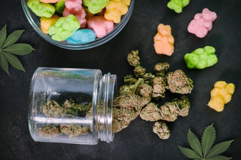 Assorted pastel Delta 8 THC gummies and a cannabis leaf, showcasing products from a delta 8 store tulsa.