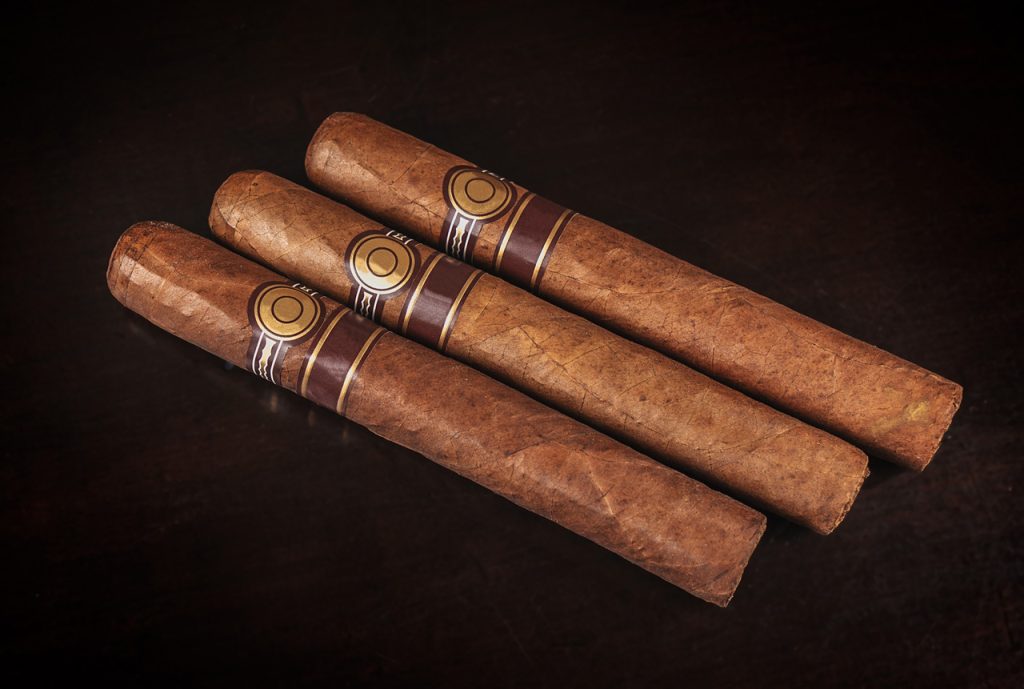 Three high-quality, dark-wrapper cigars with bands, perfect for sale at a premier cigar shop in Tulsa, Oklahoma.