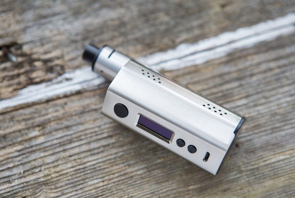 Premium silver metallic mod at a shop for disposable vapes Tulsa, featuring a digital screen on a rustic wood background. 