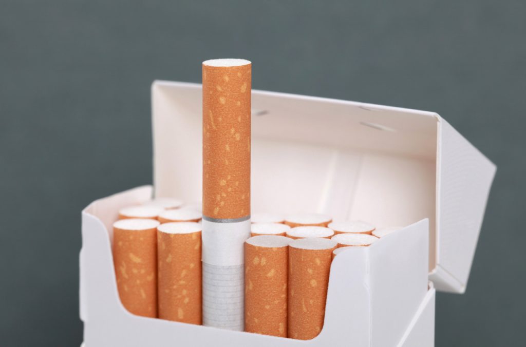 Premium cigarettes in a white pack from a tobacco shop Tulsa, featuring a close-up of a single cigarette standing up.