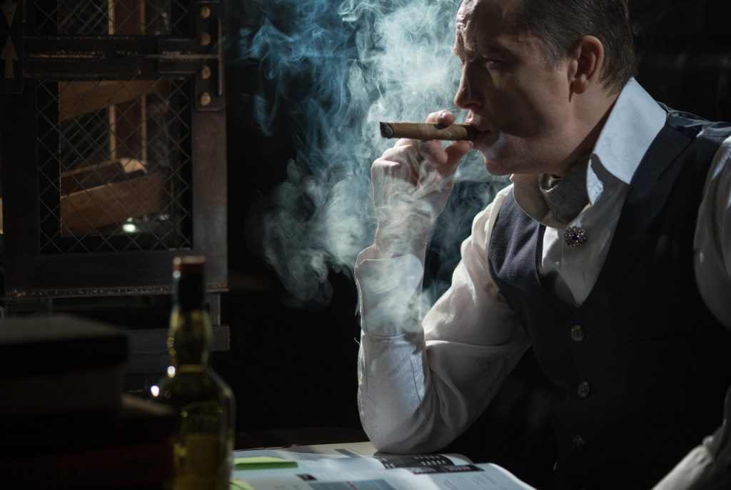 Sophisticated gentleman enjoying a premium smoke at a luxury cigar store Tulsa lounge with an upscale atmosphere.