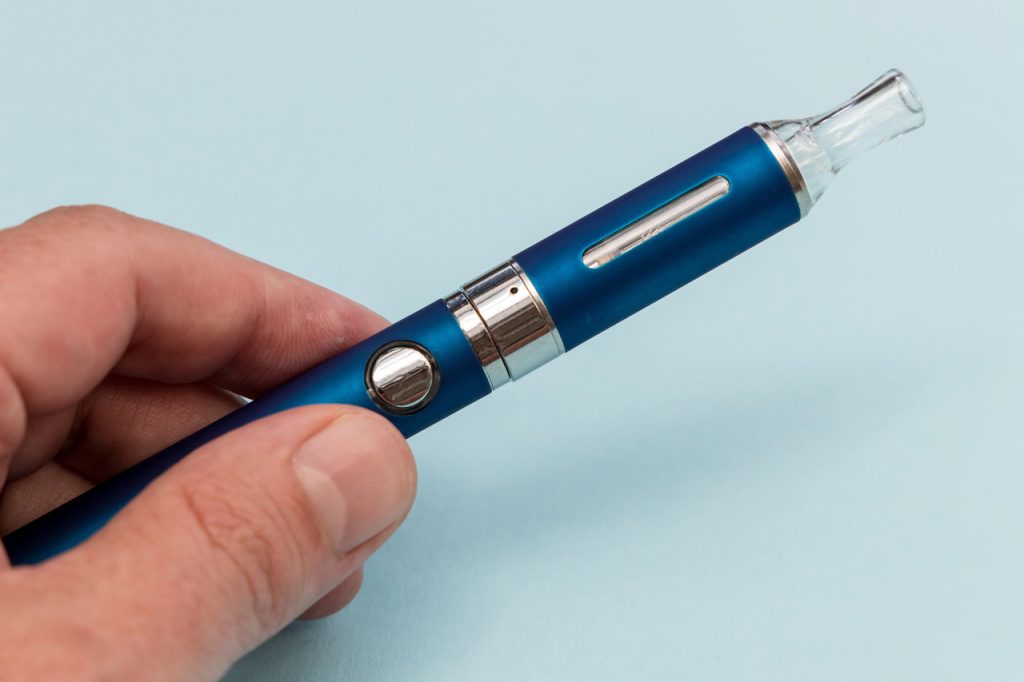 Hand holding a blue slim vape pen style device from a premium selection of vape mods Tulsa shops offer today.