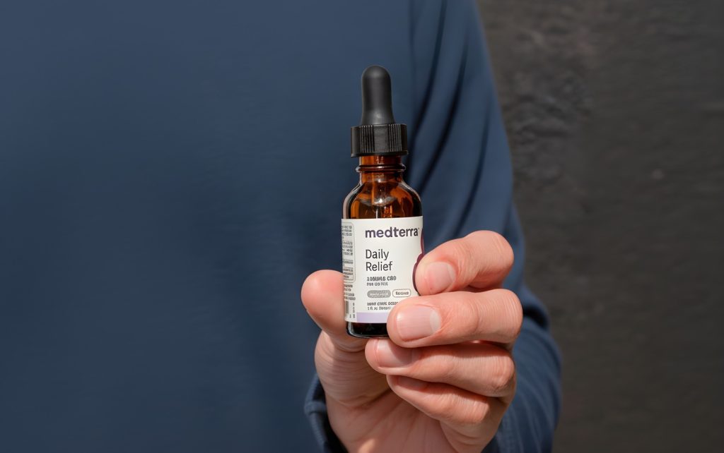 Person holding a Medterra Daily Relief CBD oil tincture bottle, highlighting easy-to-use drops from a CBD shop in Tulsa.