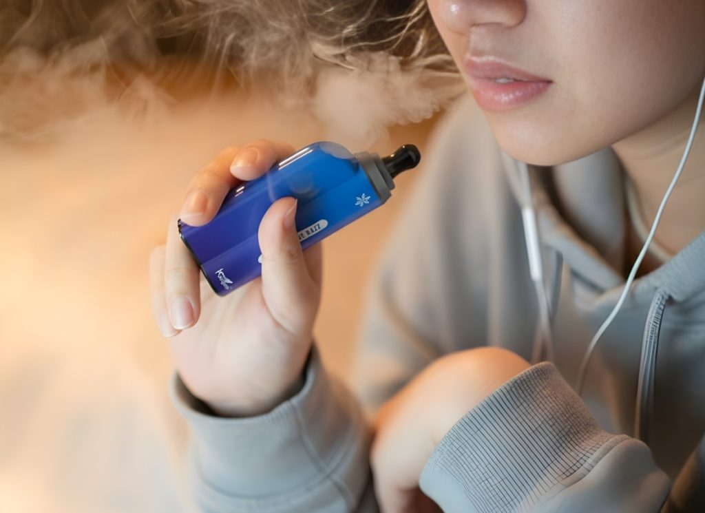 Person using a blue Kangvape pod device with vapor clouds, sourced from a local professional vape shop Tulsa.
