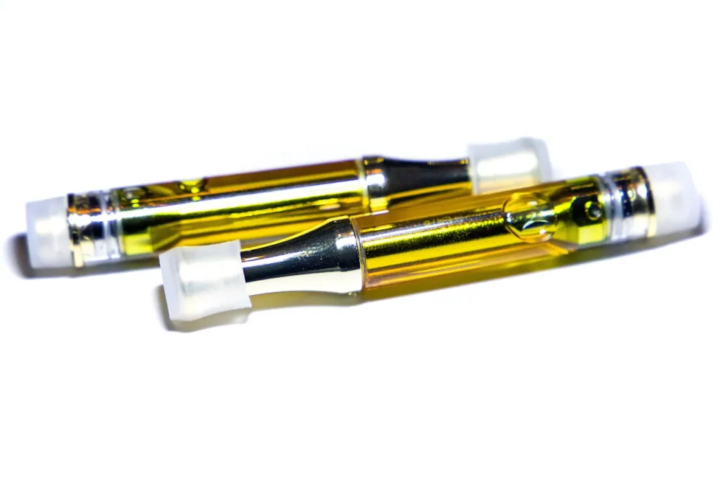 Golden oil cartridges for herbal vaporizers Tulsa dispensaries offer, shown on a clean white background.