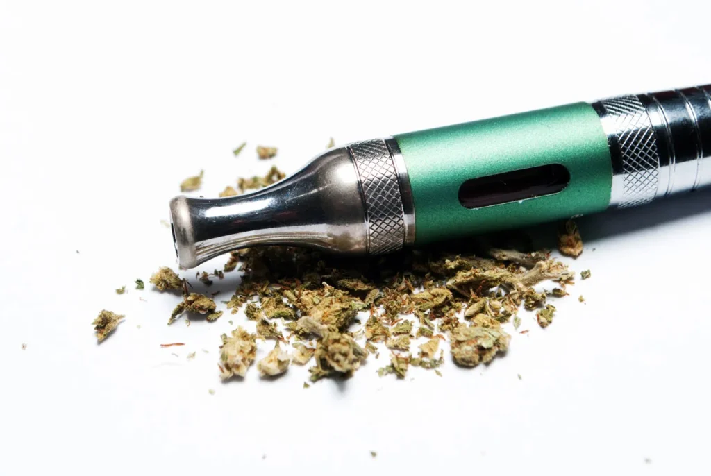 A sleek green vape pen next to ground cannabis flower, highlighting premium herbal vaporizers Tulsa options.