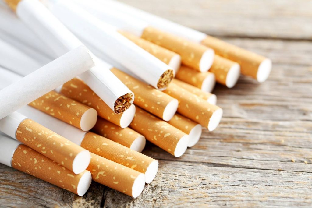 Open cigarette pack displayed against a lung x-ray backdrop for health awareness at a cigarette shop Tulsa. 