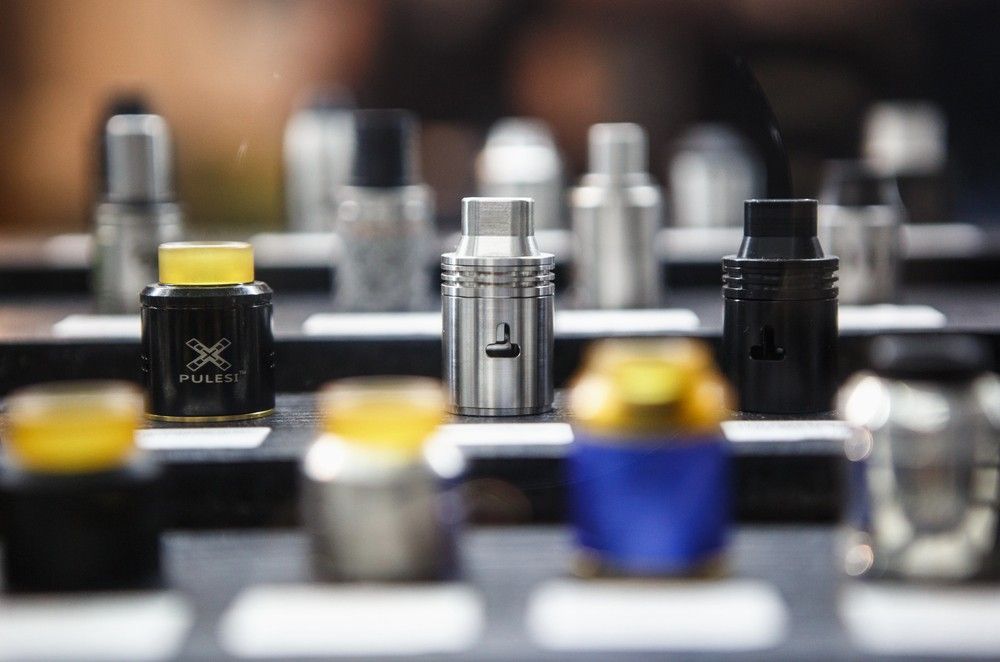 Selection of rebuildable drip atomizers and premium tanks displayed on shelves at a local vape store Tulsa OK.